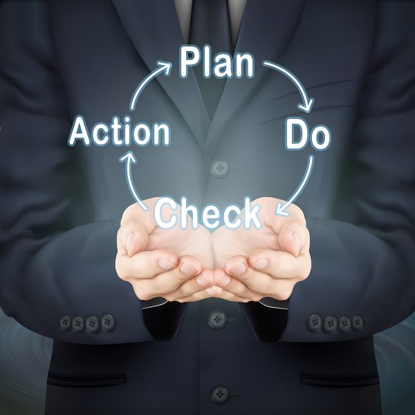 close-up look at businessman holding PDCA word